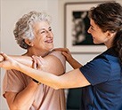 Nursing staff helping woman stretch arm